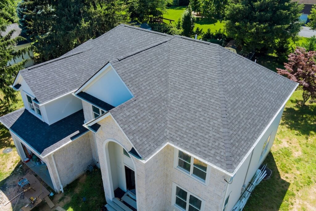 Aerial view of a large house with a gray shingle roof