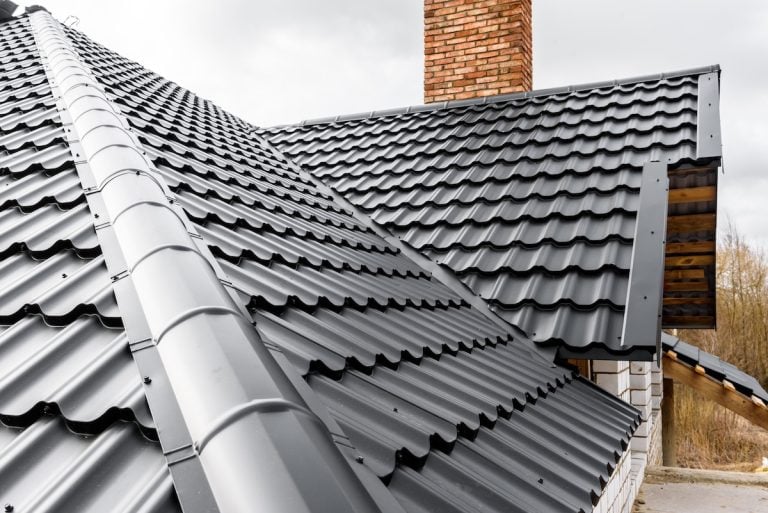 A close-up view of a modern house with a black metal roof