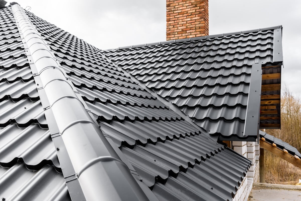 A close-up view of a modern house with a black metal roof