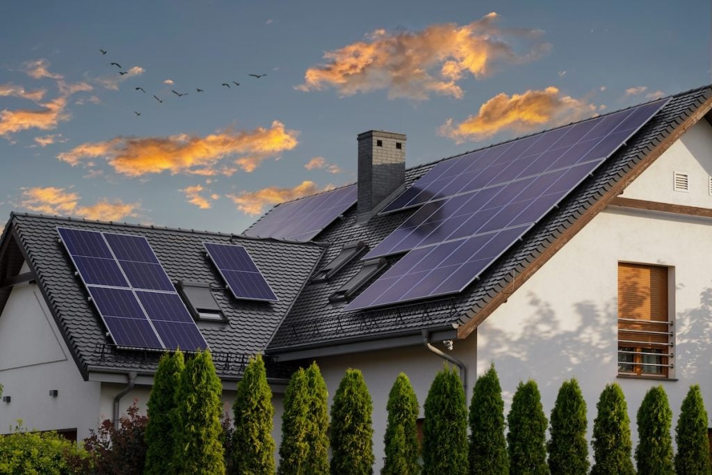 A modern house with solar panels installed on its metal roofing