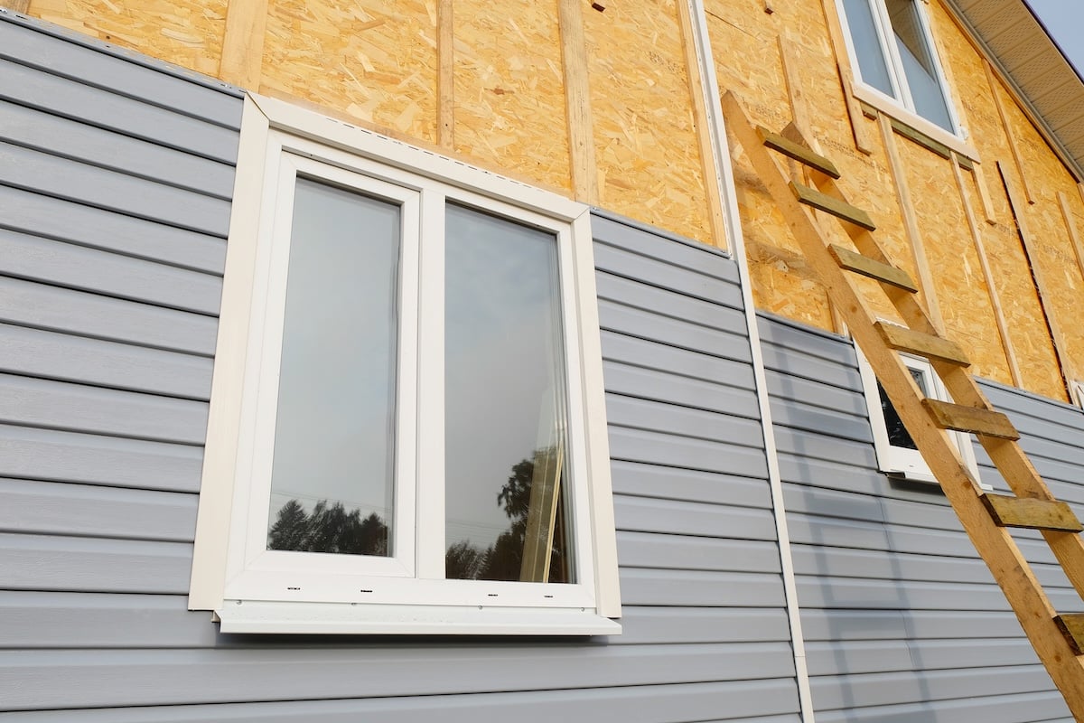 A house with gray siding partially installed