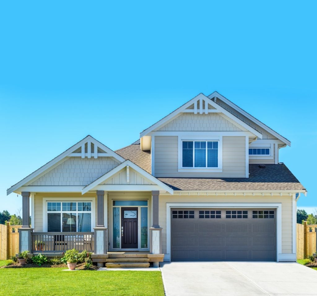 A modern two-story house with light gray siding, a front porch, large windows, and a dark garage door featuring expertly installed roofing