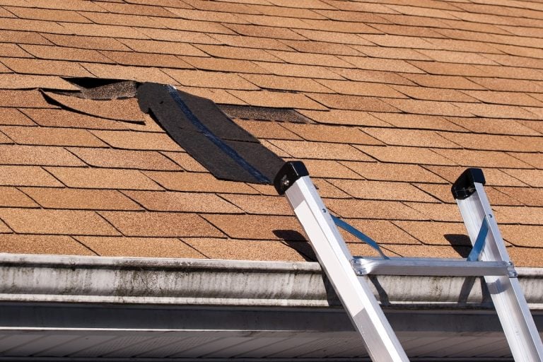 A ladder on a roof, ready for storm damage roof repair.