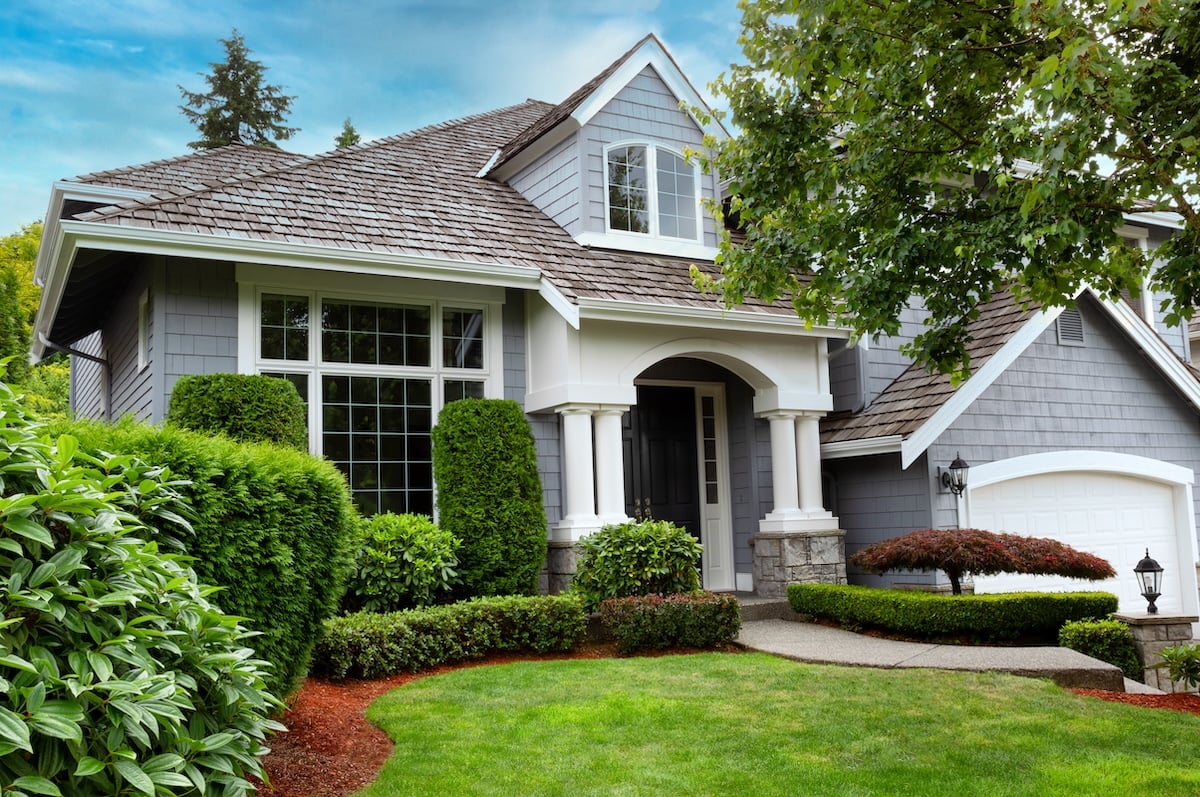 Close up view of a modern home with cedar shake roof during summer time