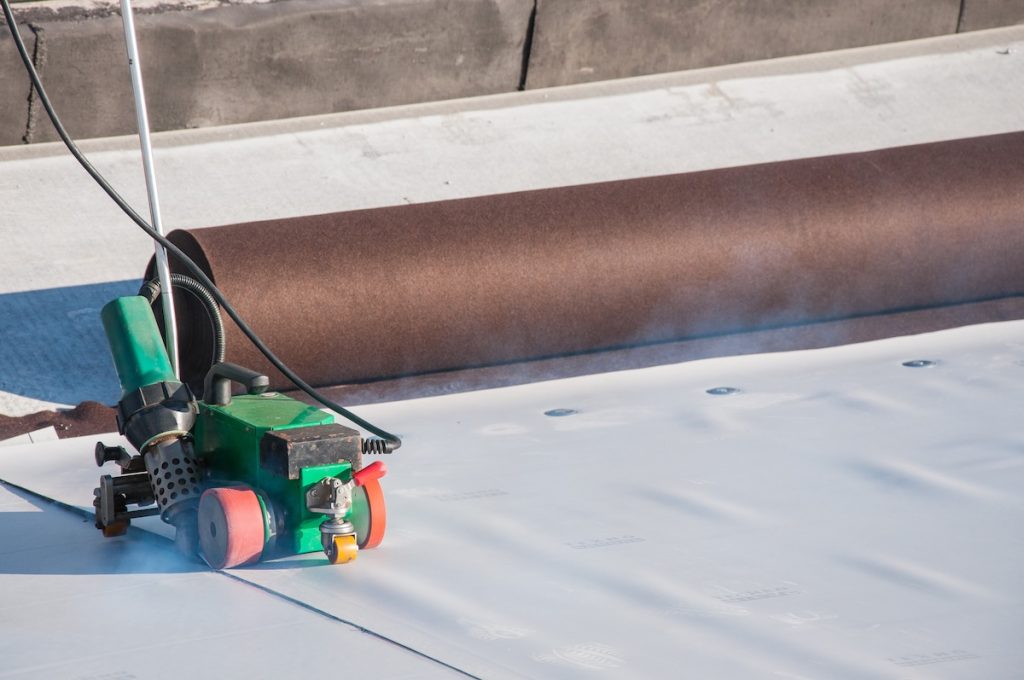 Construction device for installing waterproofing materials on the roof. Installation of waterproofing at a construction site. Protection of the roof of the building from water leakage.