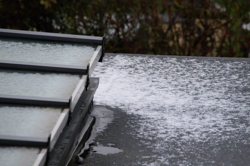 Hail sediment on flat glass roof