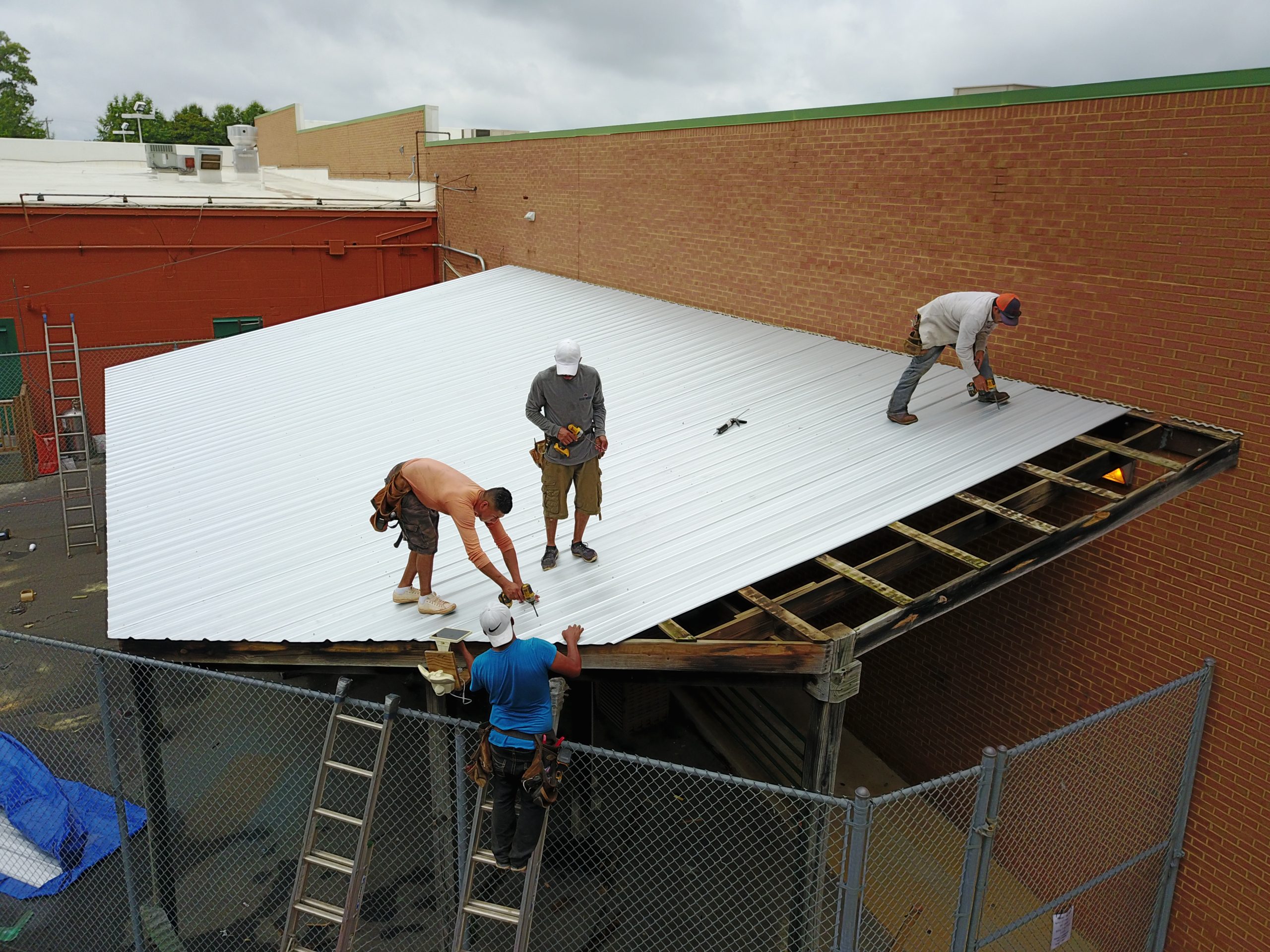 Roof medic workers fixing a commercial roof