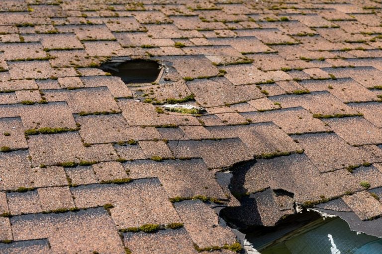 brown cracked shingles roof holes need repair house after storm