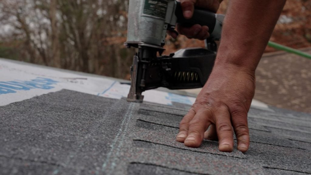 cracked shingles Roof Medic worker using nail gun repairing