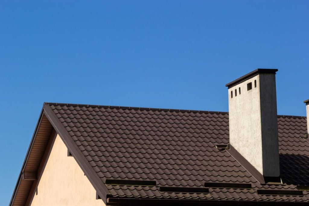 dark brown metal roof flashing blue sky summer time chimney