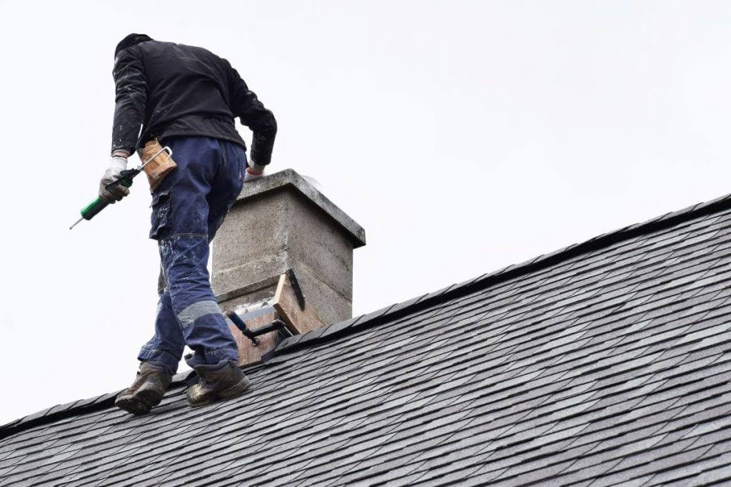 slate roof repair worker on top of roof walking
