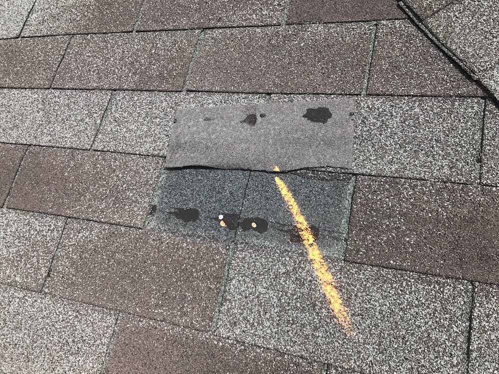 Shingle roof showing wind damage